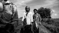 An Indian woman standing with her daughter in a crop field