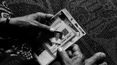 A woman holding Indian identity documents of her late husband