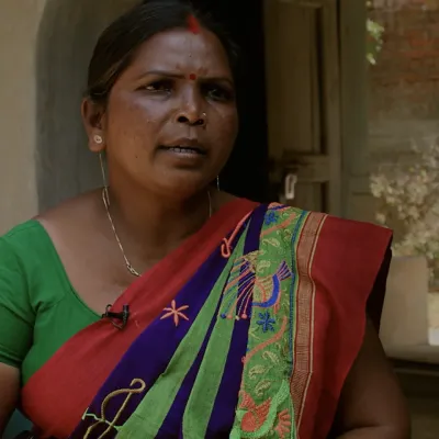 An Indian woman in a saree giving an interview while seated